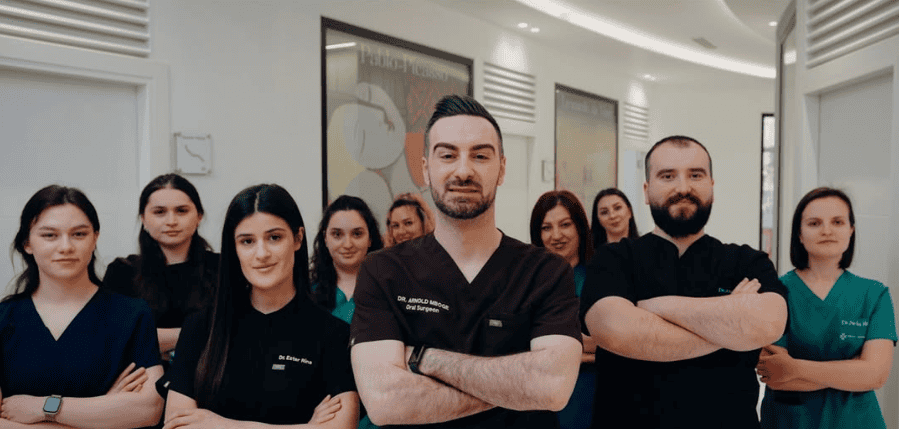 Un team di medici in camice posa con sicurezza nel corridoio di una clinica, mostrando competenza e lavoro di squadra in un ambiente sanitario.