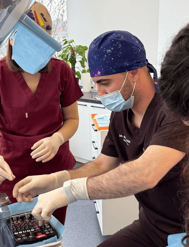 Gli odontoiatri in camice e mascherina preparano gli strumenti in un ambulatorio.