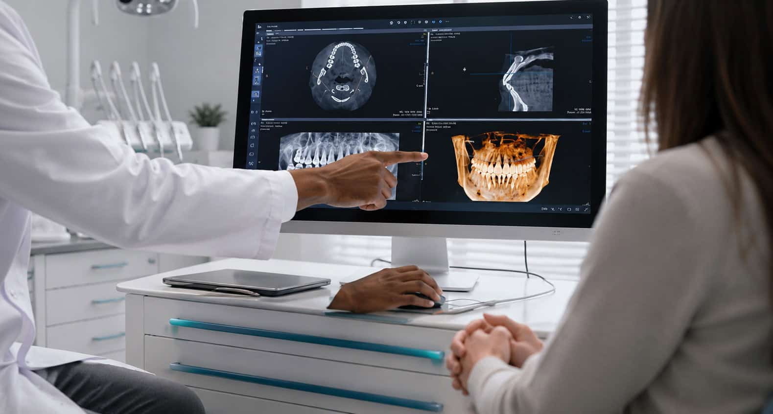 Dentist explaining dental X-rays on a computer screen to a patient in a modern clinic setting.