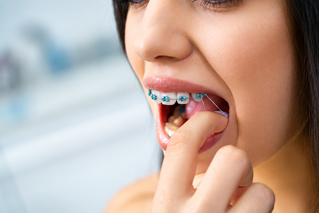 Teen with braces smiling at a dental clinic, sitting in a dentist chair.